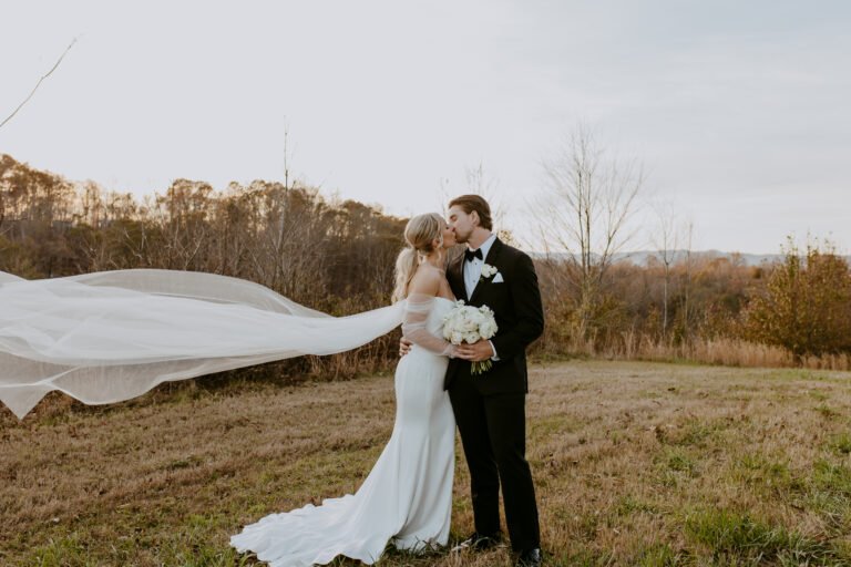 bride and groom kissing in open field